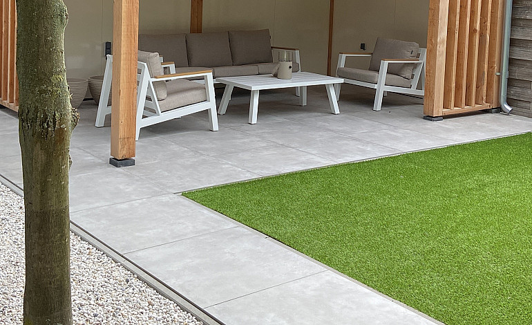 Modern terras met keramische tegels met sfeervolle overkapping 